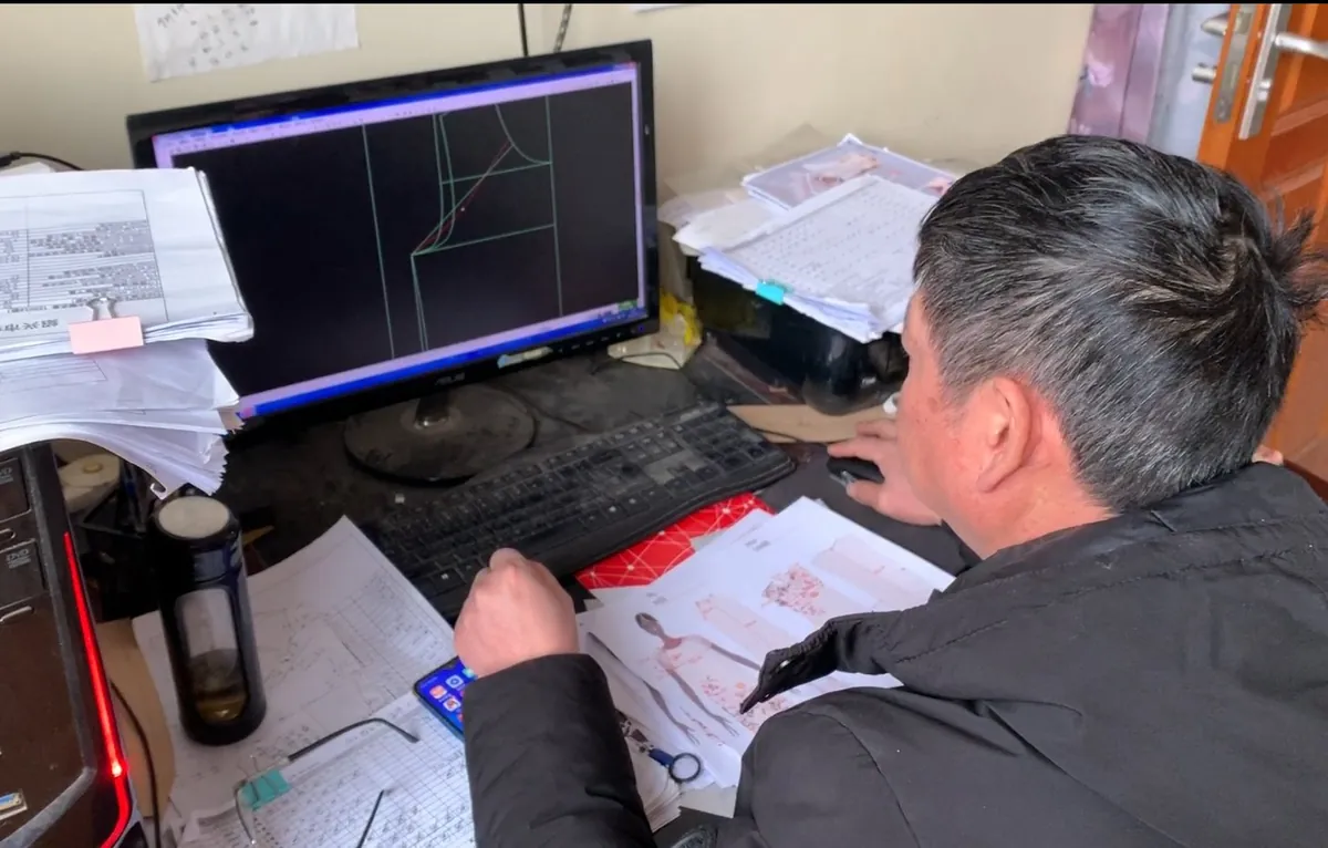 Pattern maker grading a garment pattern in CAD
