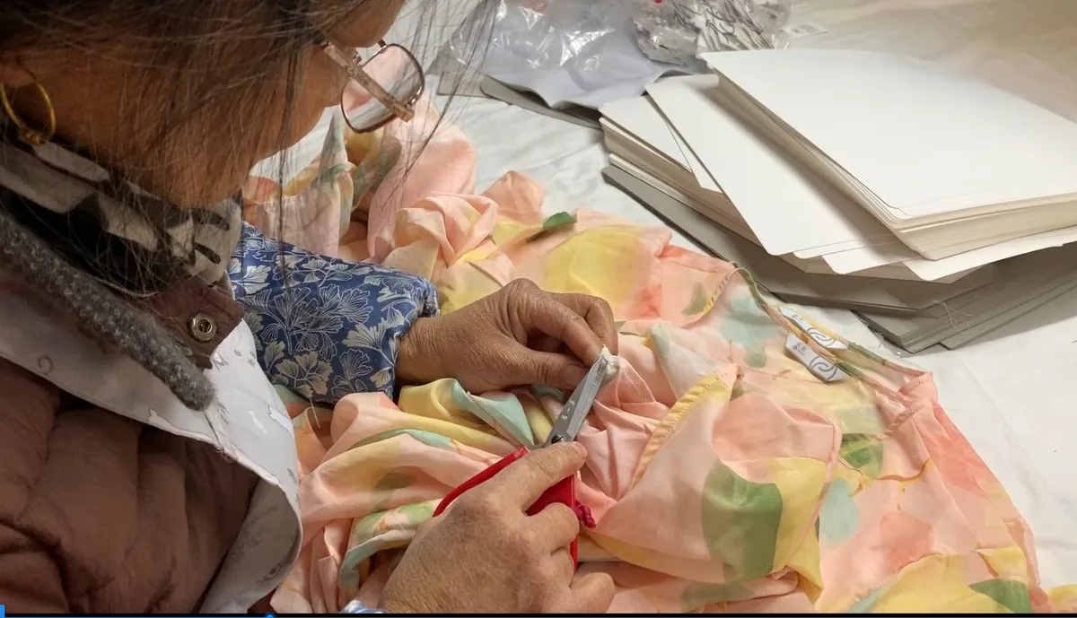 Hand thread-trimming a finished garment